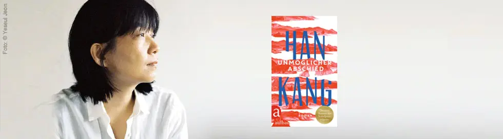 Han Kang vor einem grauen Hintergrund. Sie schaut nach rechts auf ihr Buchcover