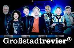 „Großstadtrevier“: Eine Gruppe in Polizeiuniformen und Zivilkleidung steht vor einem Streifenwagen.