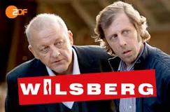 Rotes Logo mit weißem Text "Wilsberg". Zwei Männer schauen ernst. ZDF-Logo oben links.