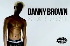 "DANNY BROWN STARDUST." Links ein dunkelhäutiger, oberkörperfreier Mann, rechts ein WARP-Logo.