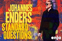 "JOHANNES ENDERS STANDARD QUESTIONS" in gelber Schrift. Ein Mann in dunkler Kleidung steht vor abstraktem Hintergrund. Logo "enja".