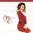 „Mariah Carey Merry Christmas“ in eleganter Schrift. Eine Frau in rotem Weihnachtskostüm kniet im Schnee.