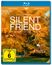 "SILENT FRIEND", Ein Film von Ildikó Enyedi. Ein Mann steht vor einem großen Baum mit goldgelben Blättern, umgeben von Gras.