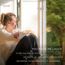 "You Made Me Laugh", Clara Guldberg Ravn, Concerto Copenhagen. Frau sitzt lächelnd im Sonnenlicht am Fenster.