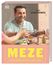 ALI GÜNGÖRMÜS, MEZE, MEDITERRANE REZEPTE ZUM TEILEN. Ein Mann lacht und stößt mit anderen über einem Tisch voller Essen an.