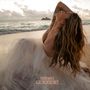 Text: "Hirie Phases". Eine Frau am Strand in einem hellen Kleid mit langen, welligen Haaren, die ins Wasser schaut., 2 LPs