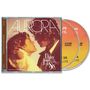 "AURORA SUPER DELUXE" und "Daisy Jones & The Six". Zwei Personen stehen sich nah gegenüber, hinter ihnen zwei CDs., 2 CDs