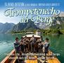 "Trompetenecho der Berge" zeigt Musiker in traditioneller Kleidung auf einem Boot vor einer bergigen Landschaft.