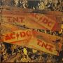 „AC/DC“ und „T.N.T.“ in roter Schrift auf Holzkisten, umgeben von Steinen und Erde., LP