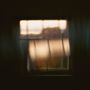 Ein verschwommenes Fenster mit diffus einfallendem, warmem Licht und vagem Ausblick., LP