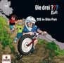 „Die drei ??? Kids: SOS im Bike-Park“. Ein Junge auf einem Fahrrad mit Helm fährt einen steinigen Pfad hinunter, gefolgt von zwei anderen Kindern. Unten links ein Europa-Logo.