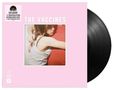 „THE VACCINES“ auf rosa Hintergrund, daneben Vinyl-Schallplatte. Bild zeigt Umarmung von Frau in weißem Top.