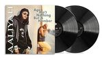 Texte: "Age Ain't Nothing But A Number", "Aaliyah". Zwei Schallplatten daneben. Person in schwarzer Kleidung mit Sonnenbrille., 2 LPs