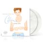 Text: "Falling Into You", "Céline Dion", weiße Schallplatten zu sehen. Frau in Top und Jeans lächelt leicht.