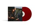 "DAY AND NIGHT", "CARLY RAE JEPSEN". Frau in dunklem Mantel an Tisch, rote Schallplatten daneben., 2 LPs
