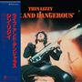 "Thin Lizzy Live and Dangerous". Ein Musiker in energiegeladener Pose mit E-Gitarre vor lebendigem Hintergrund.