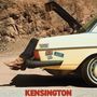 Texte: "Kensington Edition", "Plaza", "Stereo Sound". Beine in Cowboystiefeln ragen aus dem Kofferraum eines gelben Autos., CD