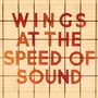 Der Text sagt: "WINGS AT THE SPEED OF SOUND". Rote Buchstaben auf einem beigen Hintergrund mit Linien.