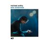 Text: "michael wollny, eine winterreise, ACT." Ein Mann sitzt gedankenversunken in bläulichem Licht.