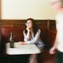 Unschärfe zeigt Person mit blauer Brille an Marmortisch, leere Flasche, rote Sitzbank, verwischter Passant., LP