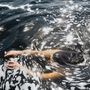 Eine Person schwimmt im Wasser, umgeben von Schaum und Sonnenlicht, das sich auf der Wasseroberfläche spiegelt., CD