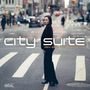 "City Suite", "Rin Seto Collective". Frau in dunkler Kleidung steht auf einem Zebrastreifen in einer belebten Stadtumgebung., CD