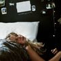 Der Text auf der Wand lautet "undividedyouare DC". Eine Frau mit blondem Haar liegt entspannt auf einem weißen Kissen., LP