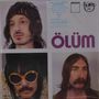 „ÖLÜM“ in lila Schrift; drei Männerporträts, oben links ein Mann mit langen Haaren, unten Männer mit Sonnenbrille bzw. Schnurrbart.