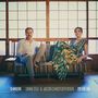 SHIKIORI, SINNE EEG & JACOB CHRISTOFFERSEN. Zwei Personen sitzen elegant auf einem Sofa vor einer traditionellen Wand., LP