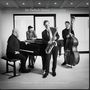 "Jan Harbeck Quartet – Concentration." Vier Musiker mit Piano, Saxophon, Kontrabass, Trommel in elegantem Raum.