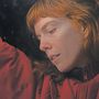 Eine Frau mit roten Haaren trägt eine rote Jacke und schaut nachdenklich in die Ferne., CD