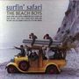 „Surfin' Safari“, The Beach Boys Albumcover. Männer auf altem Auto am Strand mit Surfbrettern. Felsen im Hintergrund.