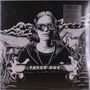 Ein schwarz-weißes Cover mit "Fever Ray". Eine Person mit Brille hält einen Stab, im Hintergrund sind Häuser.