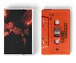 Ein leuchtend orangefarbenes Kassettenband mit "OCTOBER NIGHTS" und "OCTOBER LONDON". Daneben ein dunkelrotes Foto., MC