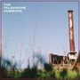 Text: "THE TELEPHONE NUMBERS". Rostiger Schornstein auf einem Fabrikgelände vor klarem blauen Himmel, grasige Vegetation im Vordergrund., CD