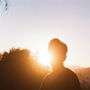 Ich kann keine Texte oder Details in diesem Bild erkennen. Eine Person steht im Gegenlicht der tief stehenden Sonne., LP
