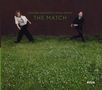 Johanna Borchert & Miles Perkin, The Match. Zwei Personen stehen auf einer grünen Wiese vor einer dunklen Wand., CD