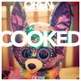 Oben "OREN AMBARCHI", groß "COOKED", unten "DC994". Darunter eine bunte, glitzernde Plüschfigur., CD