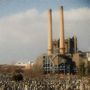 Keine Texte. Eine große Industrieanlage mit hohen Schornsteinen im Hintergrund, ein Friedhof mit vielen Grabsteinen im Vordergrund., LP