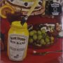 Auf rotem Tischdecke steht ein Glas mit "Scott Hepple and the Sun Band English Mustard". Daneben sind Obst und Kuchen., LP