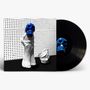 Illustration: Blaues Totenkopf-Motiv auf weißer Skulptur und Vinylplatte vor perforierter Wand., LP