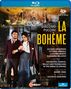 Der Text beschreibt eine Aufführung von "La Bohème" in Verona. Zwei Personen in Kostümen stehen im Vordergrund.