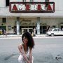 Großes Schild mit „AMÉRICA“, darunter „Teatro América“, Frau mit lockigem Haar im Fokus, Straße, alte Autos., CD
