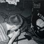 Text: "frail No Industry". Schwarz-weiß Foto, Sänger kniet mit Mikrofon, Gitarre und Trommel im Hintergrund. Schallplatte dabei., LP