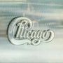 "Chicago" in geschwungener Schrift vor einem metallischen Hintergrund. Logo-Stil mit eleganter Typografie., LP