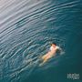 Text: "saturdays at your place". Eine Person schwimmt im Wasser, umgeben von sanften Wellen., LP
