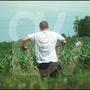 Großes, halbtransparentes "OV". Zwei Männer im Feld, der vordere im weißen T-Shirt läuft, der hintere schaut., LP