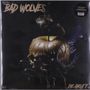 Text: "BAD WOLVES" oben und "DIE ABOUT IT" unten.  
Schädel mit goldener Flüssigkeit auf schwarzer Hand., LP