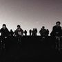 Gruppensilhouette von Menschen, die abends auf Fahrrädern fahren; dunkler Himmel im Hintergrund., CD