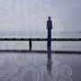 Große, fließende Buchstaben: "SHIFTING SHORES". Person auf Steg über Wasser, trägt gemustertes Outfit und Hut., CD